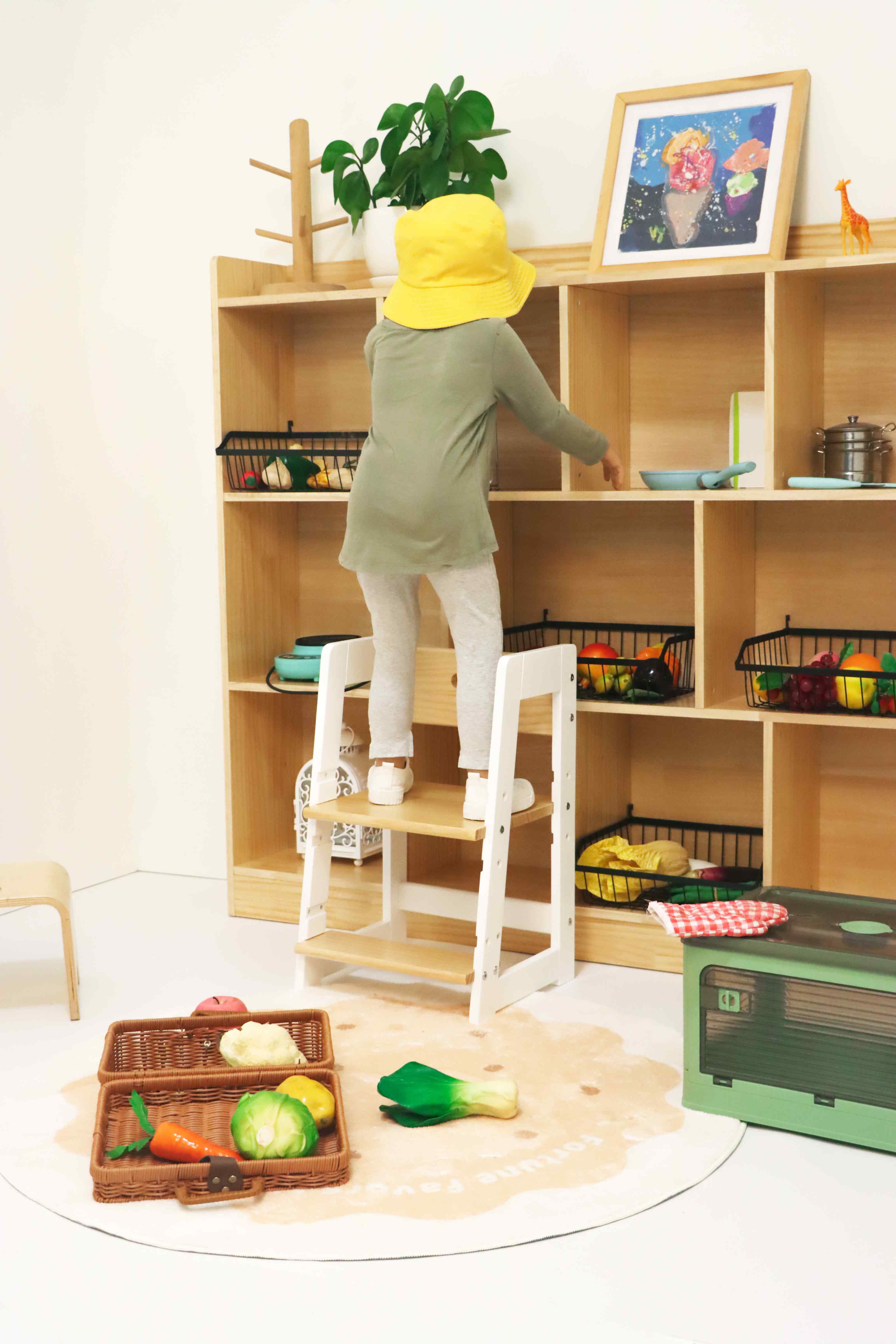 Child safely standing on a kids helper to reach elevated areas